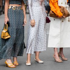 a group of women wearing dresses and skirts pose together 