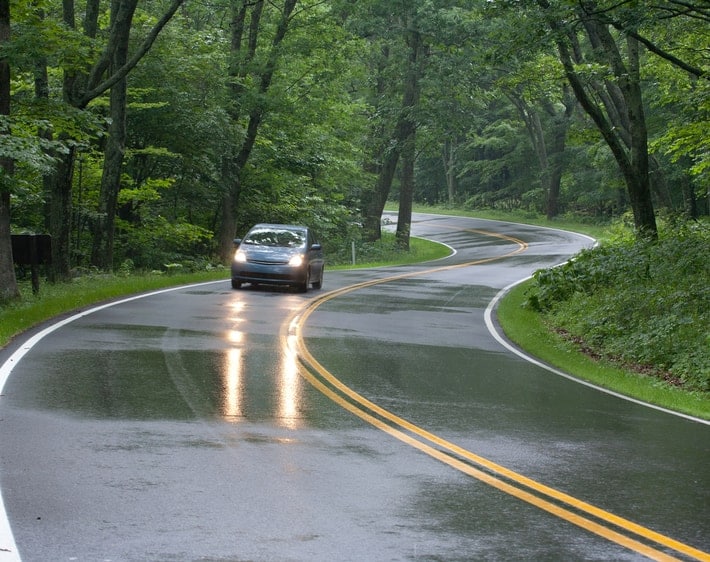 hatchback driving down winding wet road