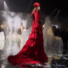 a model wears a long red dress on the Valentino runway 