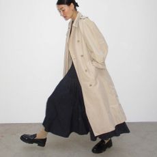 woman wearing trench coat and long skirt