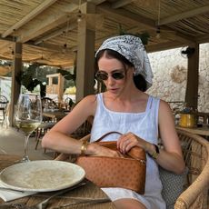 Woman wearing a white linen dress and a headscarf