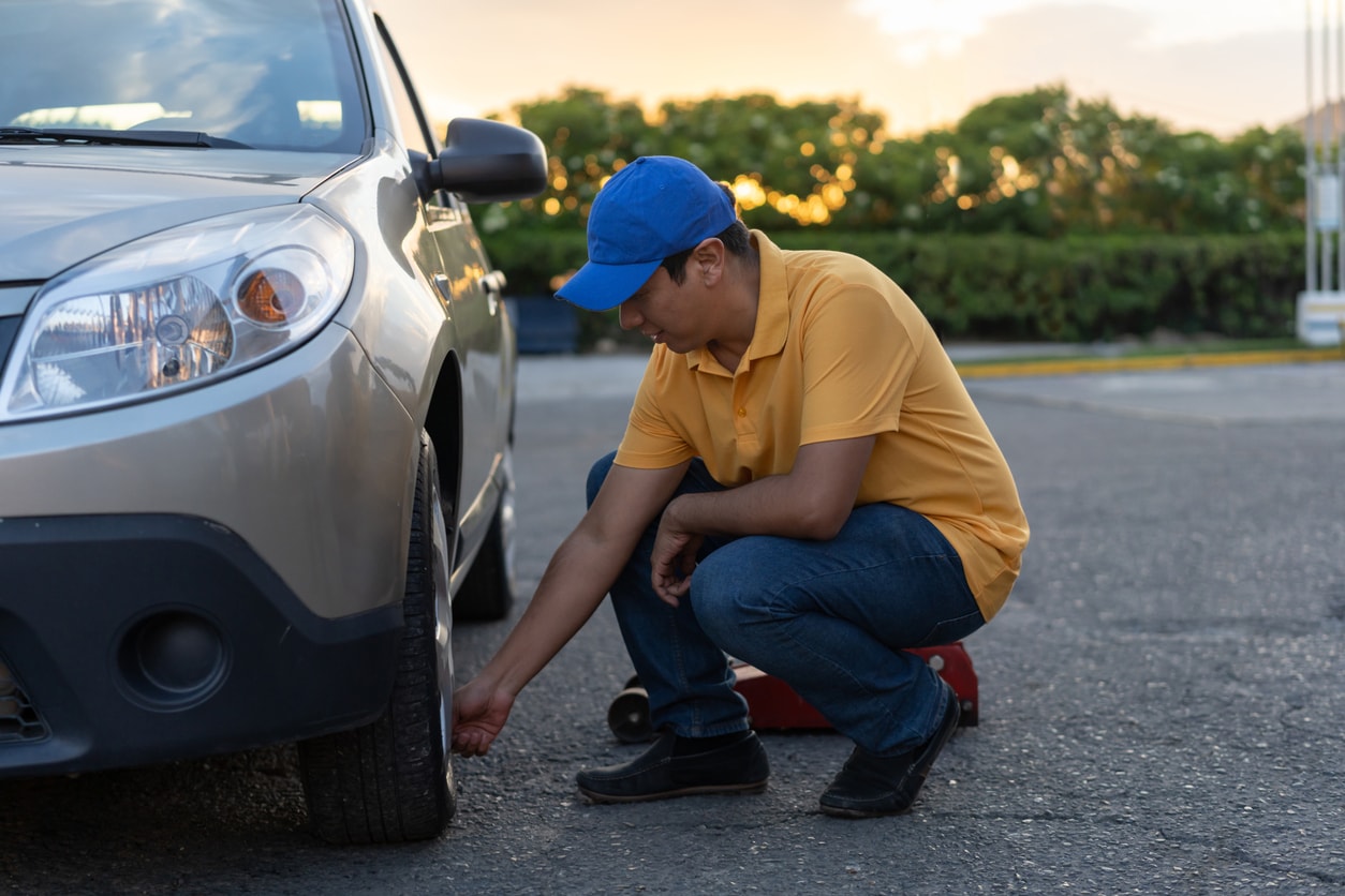 image of a man checking his tire pressure